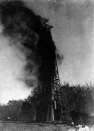 1897-NellieJohnson A crowd watches the Indian Territory's first oil gusher in 1897.