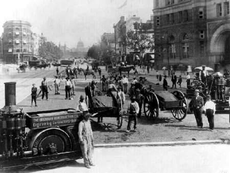 Asphalt-Capitol-AOGHS Workers with shovels toil as Pennsylvania Avenue is being paved with asphalt in 1907. Capitol dome is visible in background.