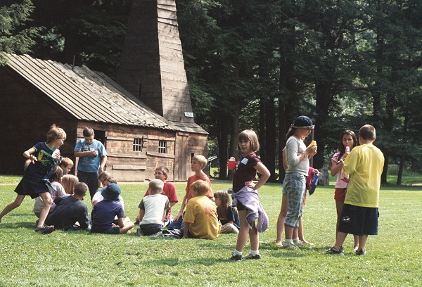Children play in front of Drake Well Museum derrick and engine house in PA.