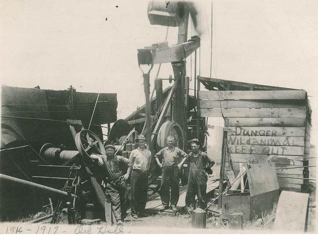 Roughnecks pose in front ofa Kansas oil well circa 1930.