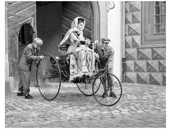 Three-wheel first car with Bertha Benz driving it.