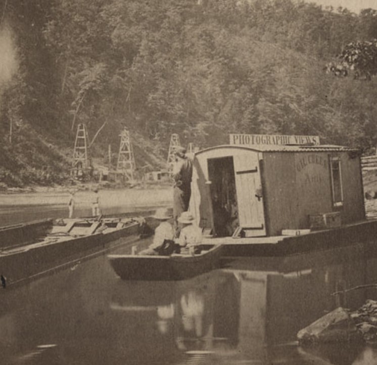 John Mather's floating studio and dark room with derricks in background.