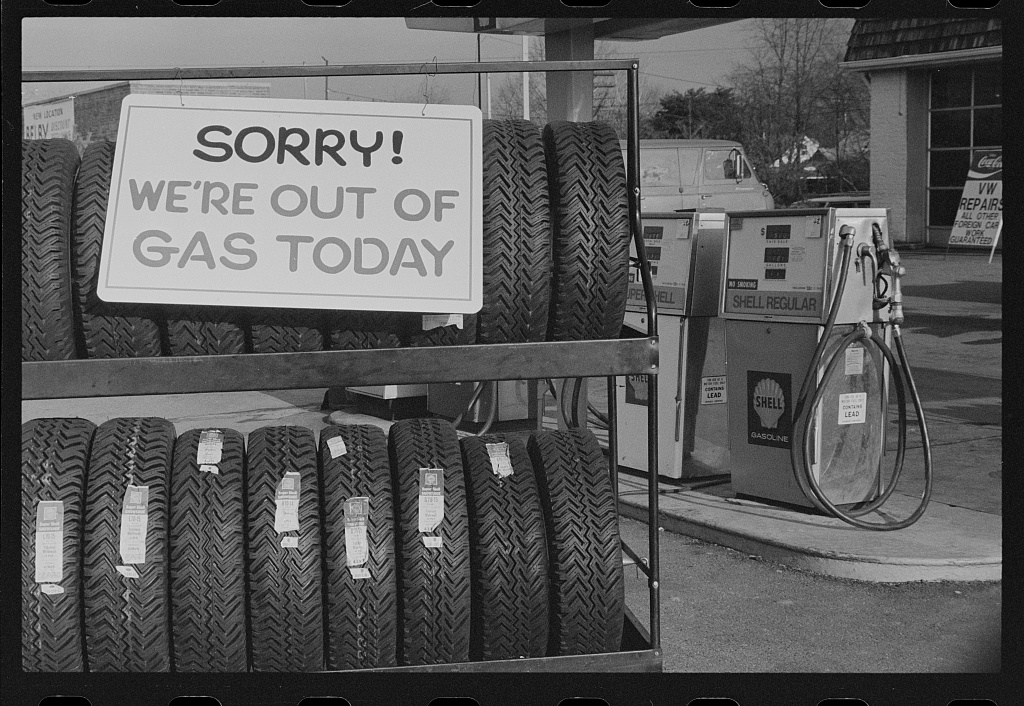 gas station sign above tires in a rack. Sign says "Sorry we are out of gas today."