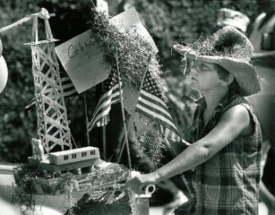 shrimp-fest-1985-Louisiana Woman pushes a cart with model derrick and American flags in this news photo.