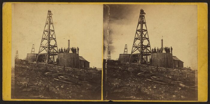 Stereograph of circa 1860s PA oil well with wooden derrick, tank, and workers..